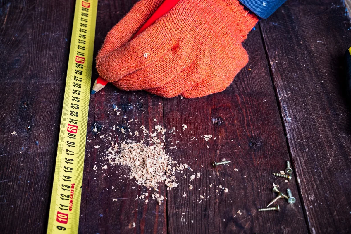 Mètre, crayon, vis et outils de construction préparés avant chantier, illustration du matériel nécessaire avant une pose de terrasse sur plots