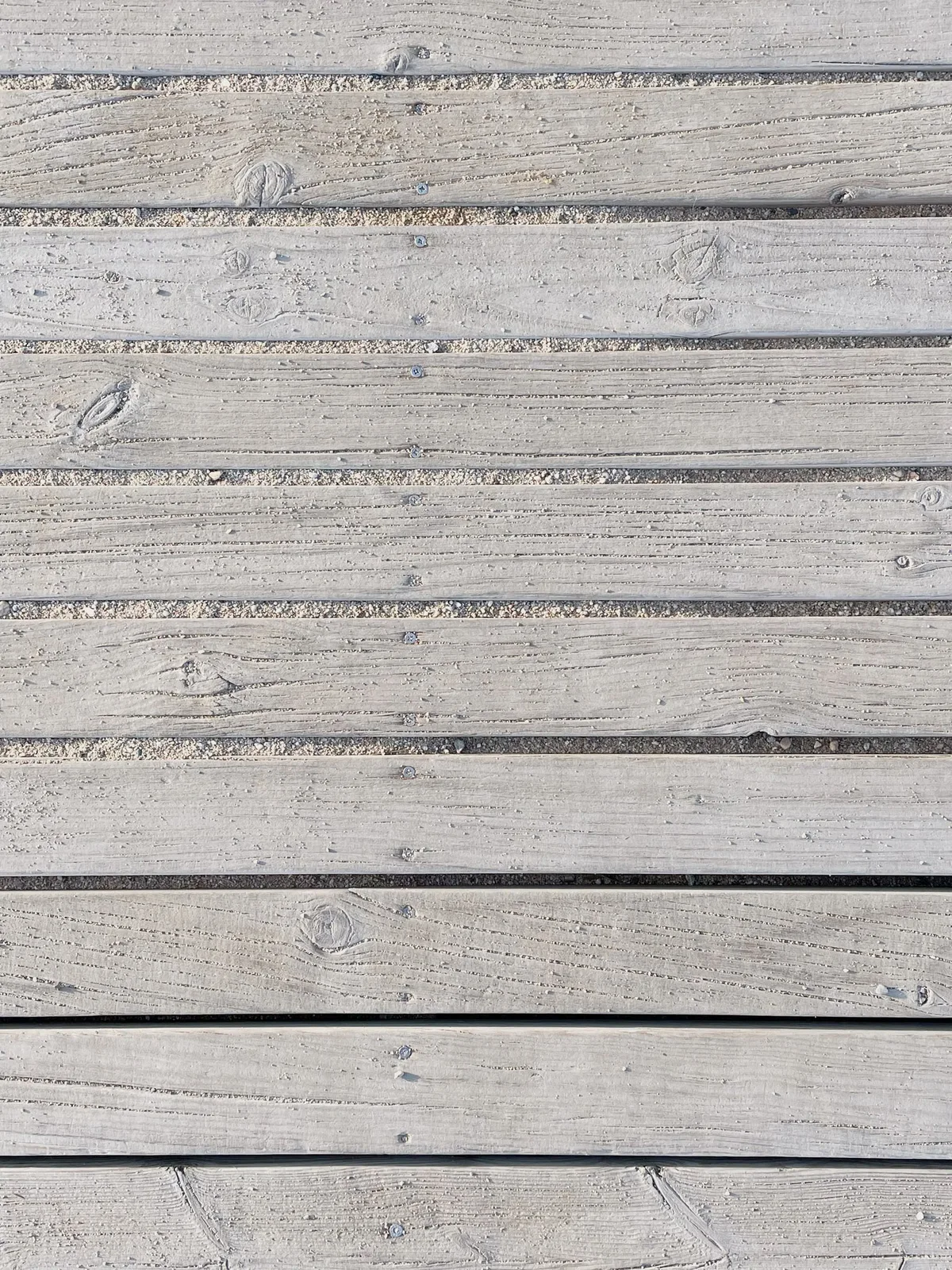 Gros plan sur des lames de bois et leurs joints réguliers, illustration des espaces nécessaires au fonctionnement d'un platelage extérieur