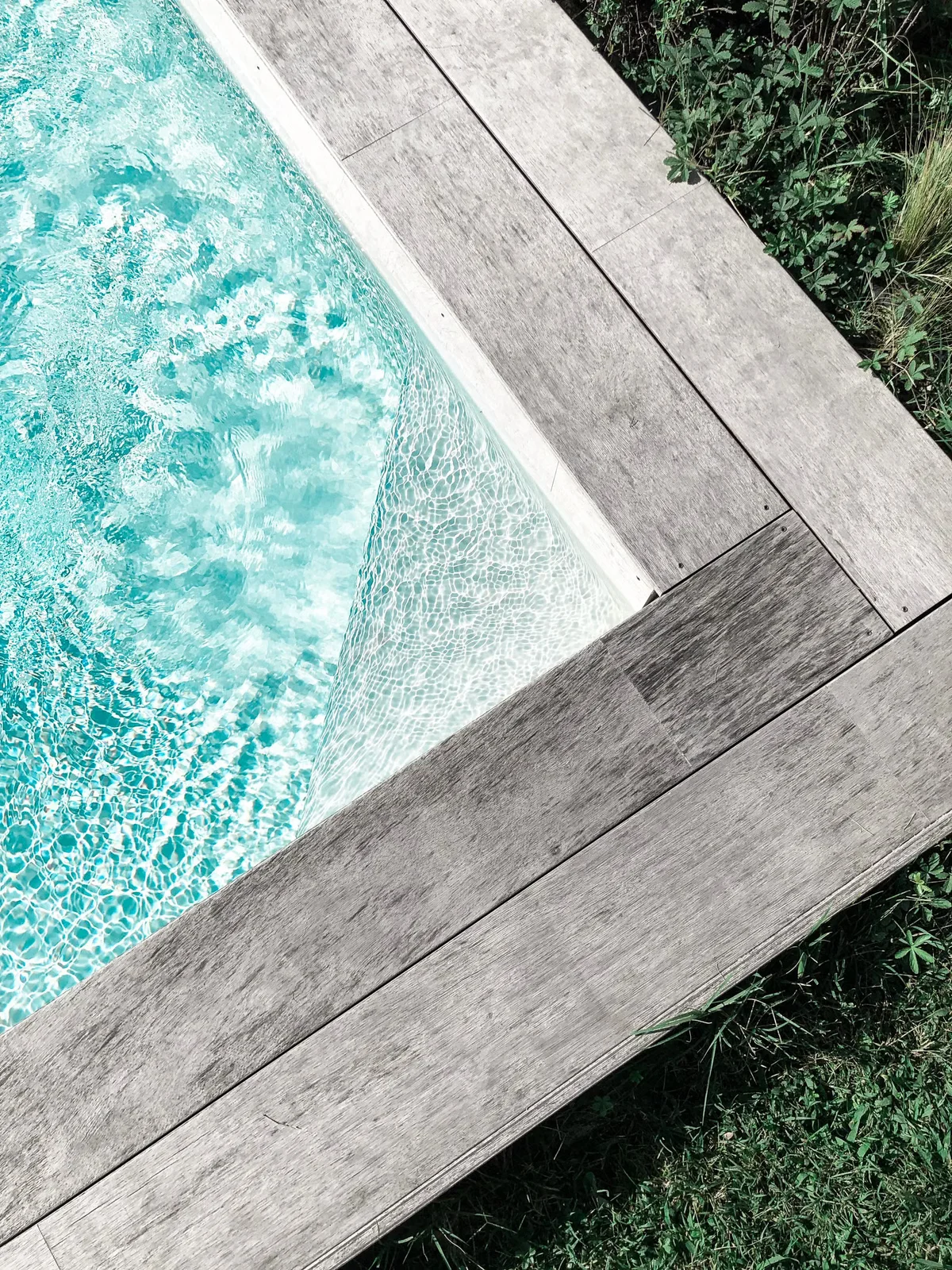 Bord de piscine avec platelage en bois illustrant une zone fréquemment mouillée et exposée aux éclaboussures