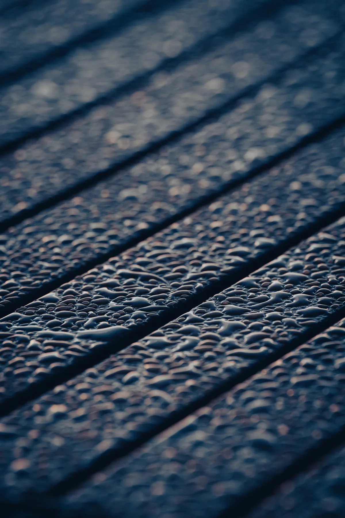 Gouttes d'eau visibles sur une surface en bois, illustration de l'humidité réelle des lames à considérer avant leur mise en œuvre