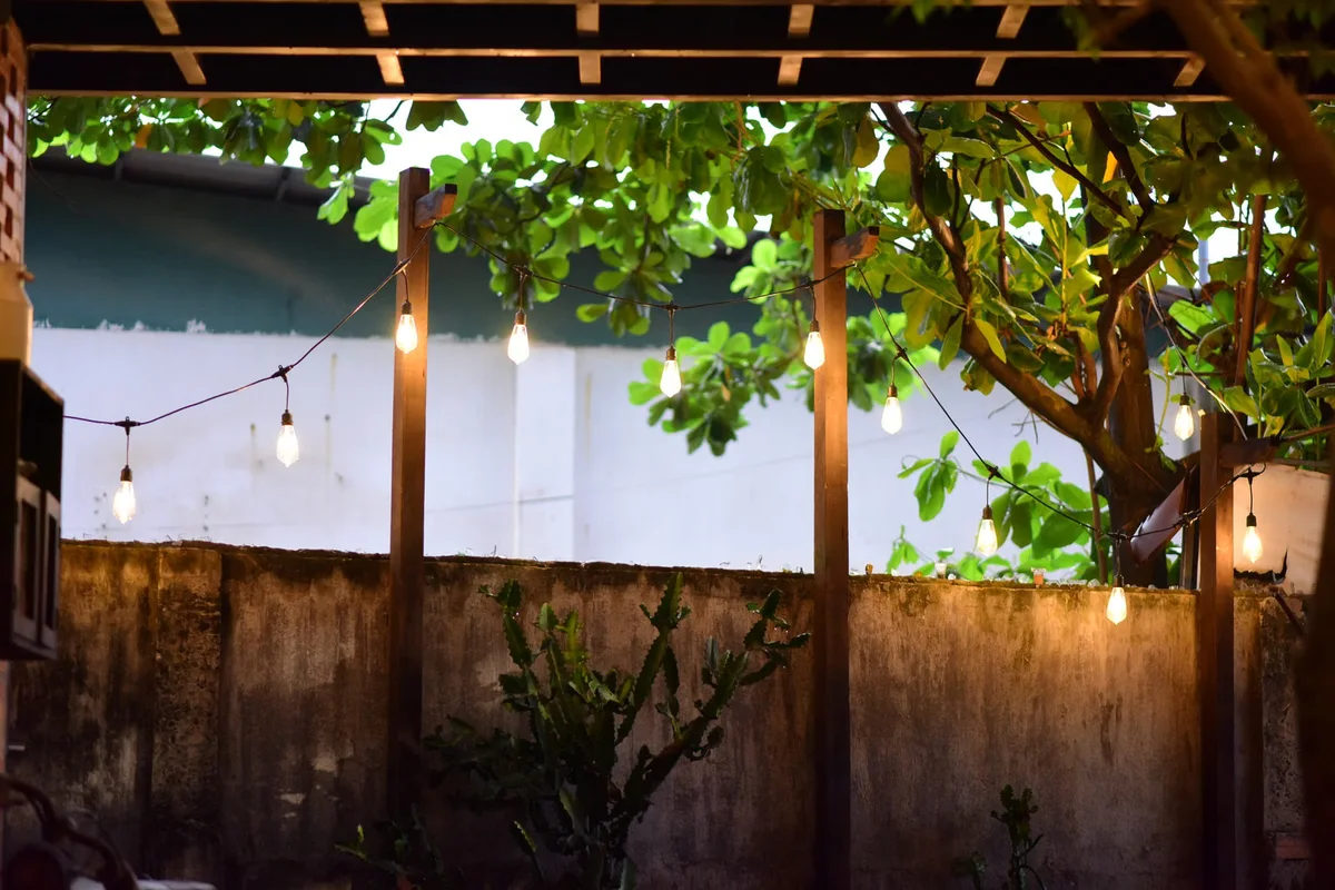 Patio extérieur éclairé en soirée, illustration du rôle de l'éclairage pour le confort, le cheminement et l'ambiance d'une terrasse