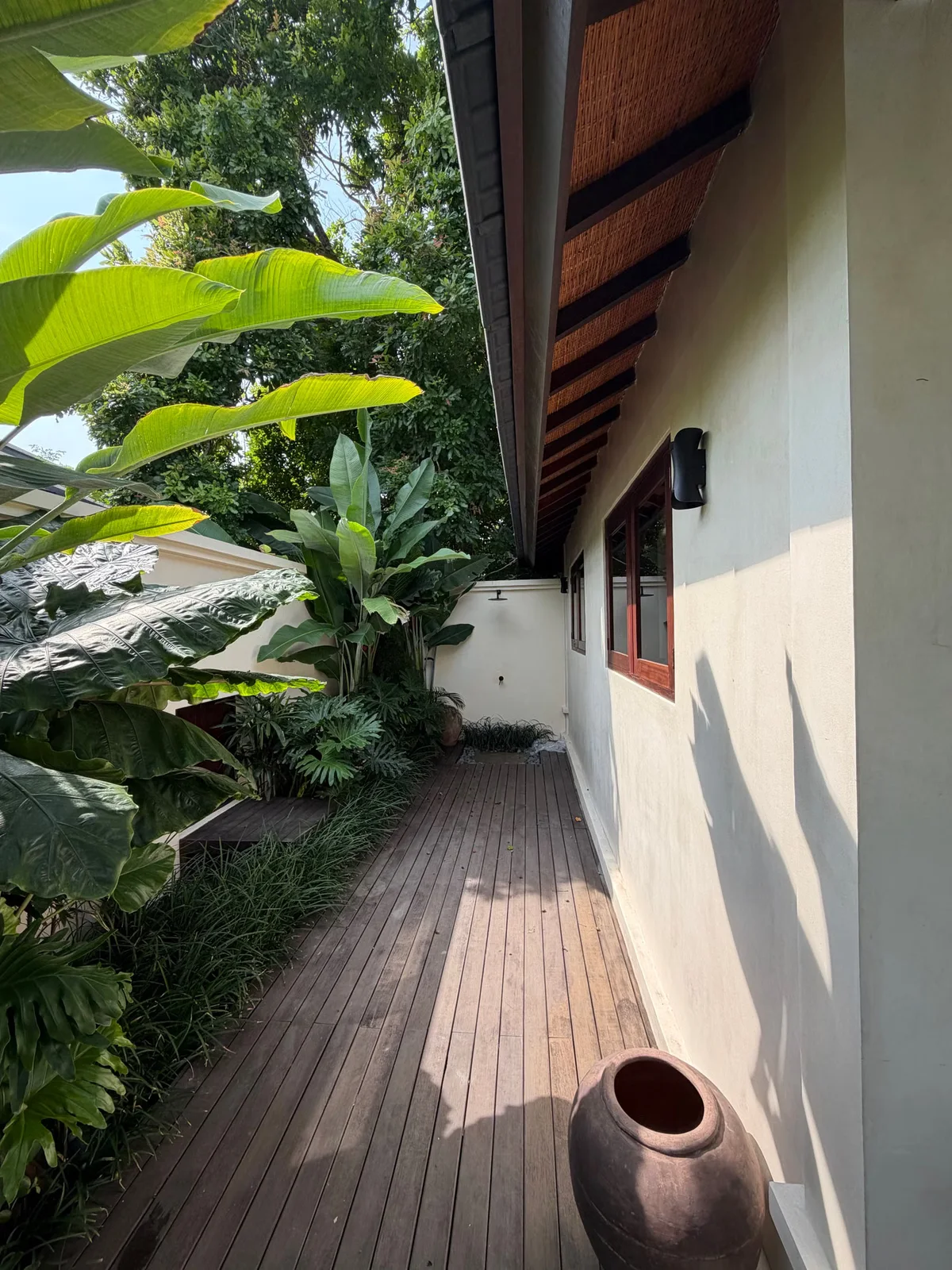 Terrasse en bois intégrée à une végétation dense, illustrant l'évolution d'un platelage exposé dans la durée