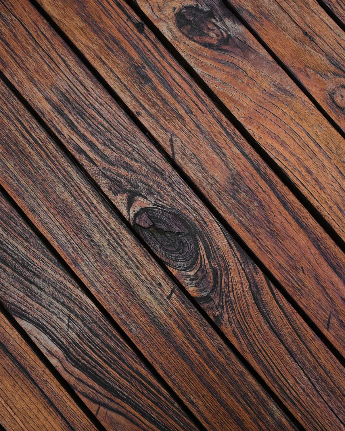 Gros plan sur des lames de terrasse en bois montrant leur texture et leur patine de surface