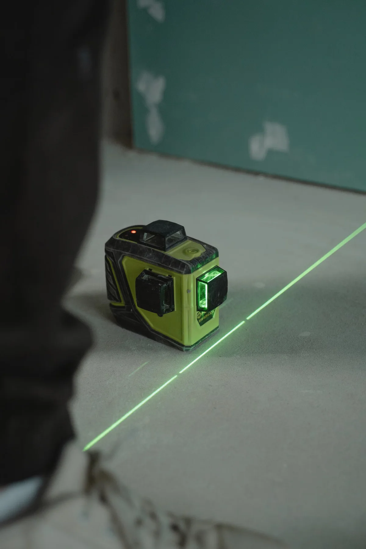 Niveau laser projetant une ligne de contrôle, illustration de la mesure des niveaux et de la pente d'un support avant pose
