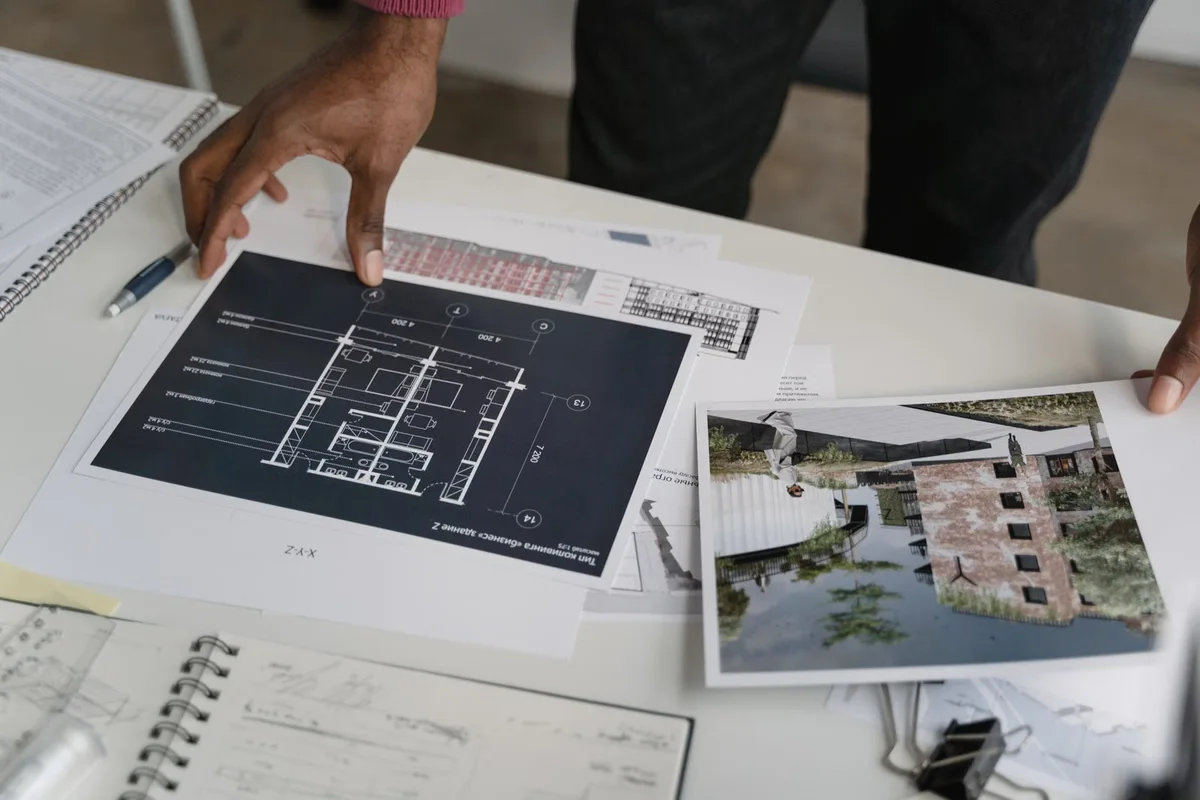 Mains analysant des plans de construction, illustration de la comparaison poste par poste d'un devis de terrasse