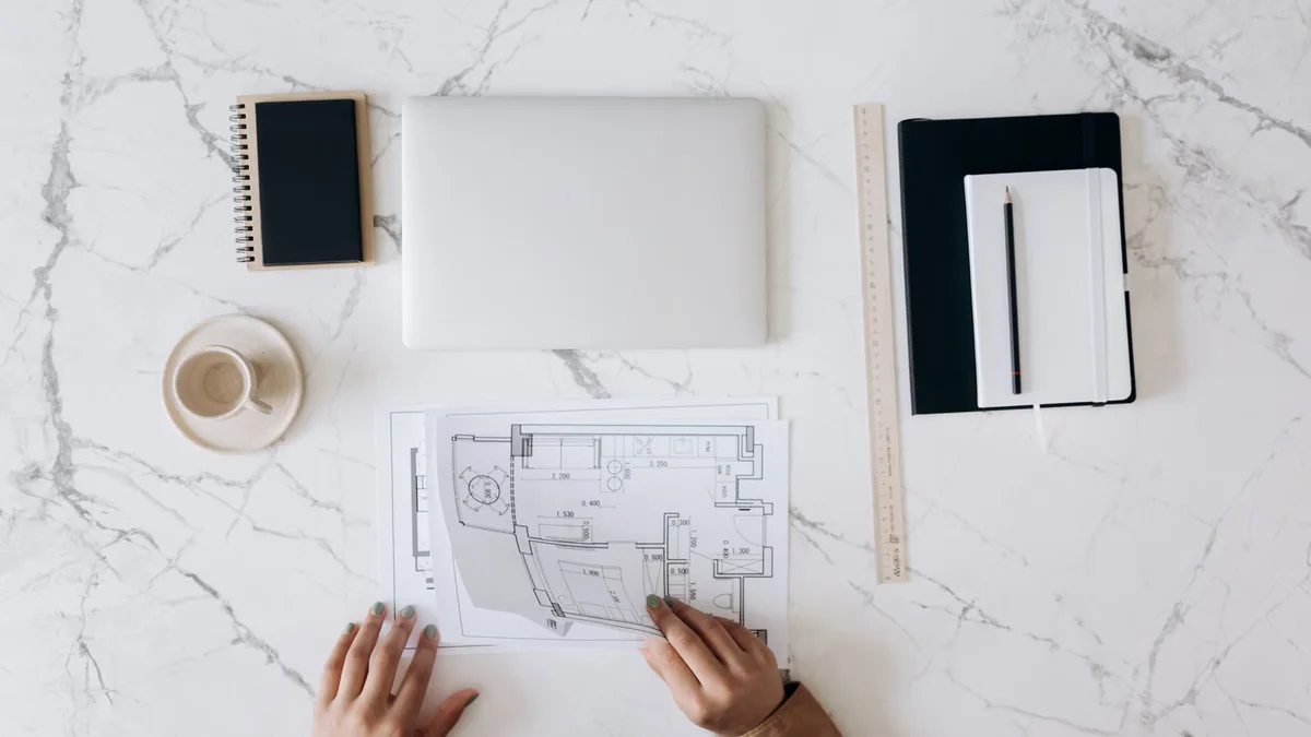 Bureau d'architecte avec plans et outils, contexte de préparation d'un projet dont l'impact peut nécessiter un permis de construire