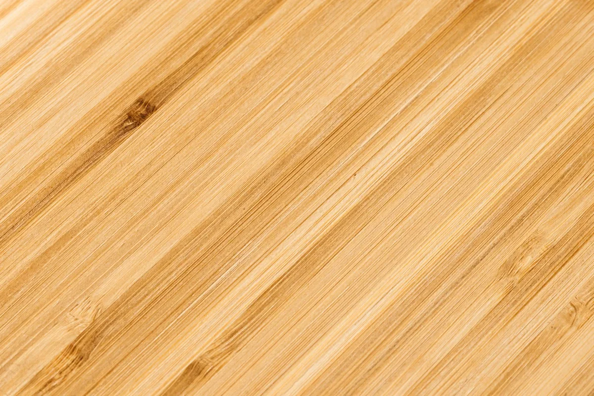 Gros plan sur une surface en bambou montrant son grain et sa structure régulière, illustration du matériau transformé utilisé dans les produits en bambou