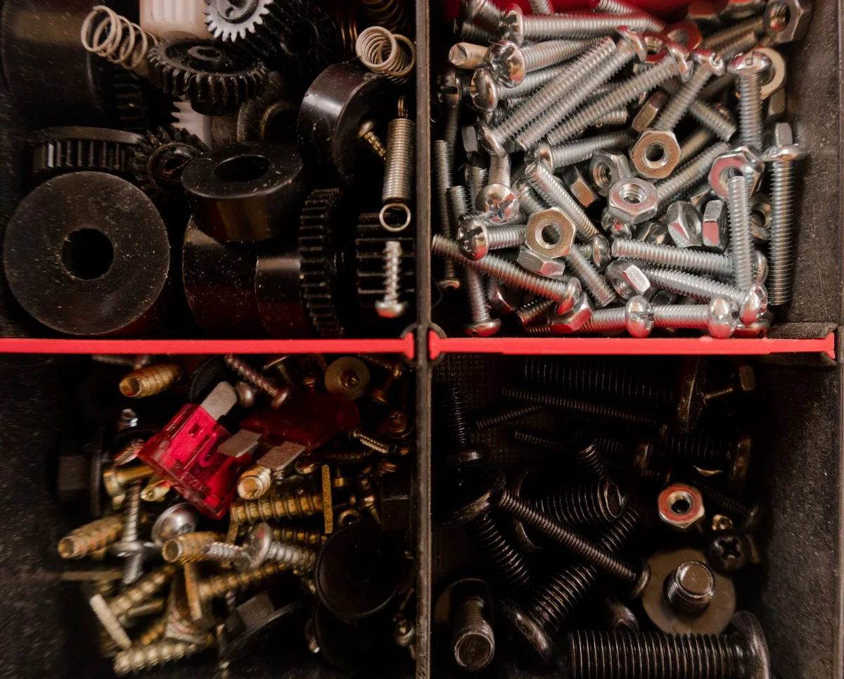 Assortiment de vis et de pièces de fixation, illustration des différentes familles de quincaillerie utilisées pour assembler un platelage