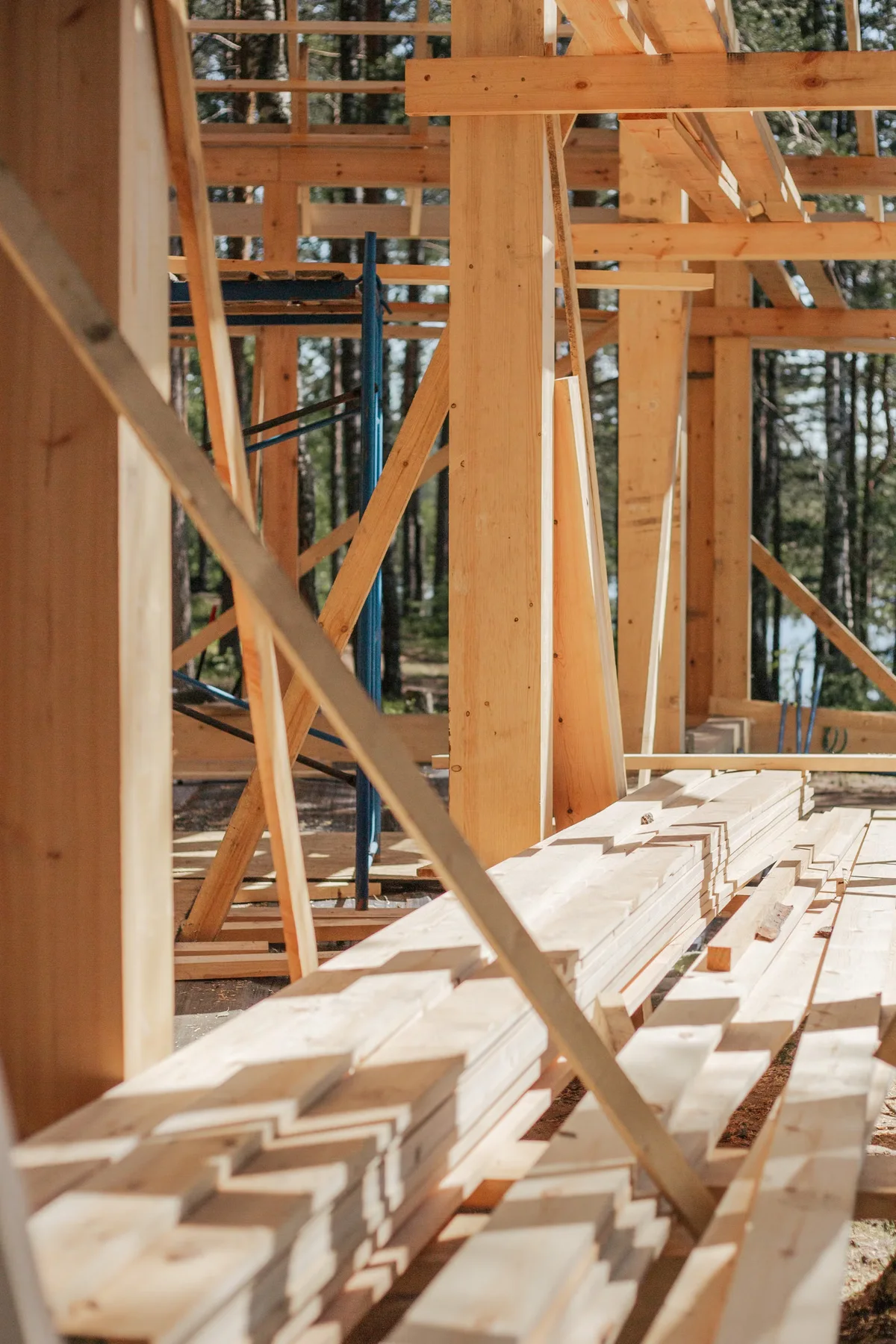 Bois préparé sur un chantier extérieur, illustrant les volumes de matière qui évoluent avec la surface de terrasse