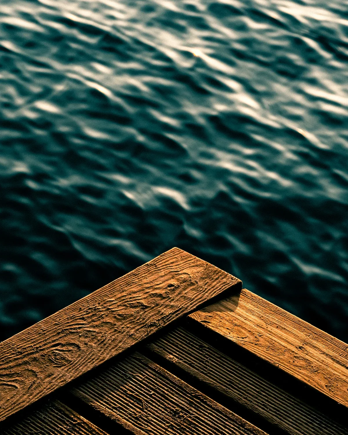 Gros plan sur un platelage en bois au contact d'un environnement aquatique, illustration des critères de surface, stabilité et exposition à comparer