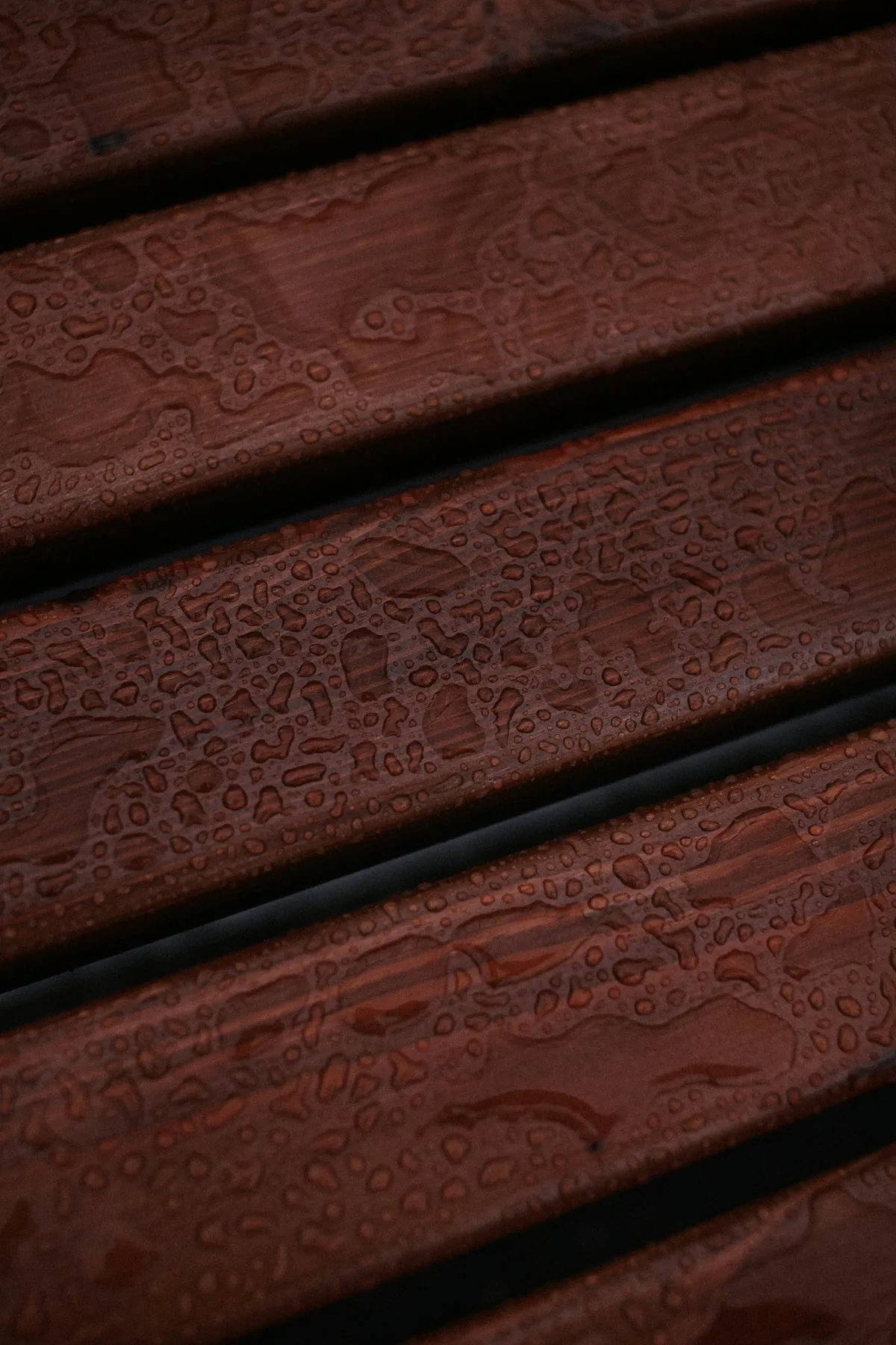 Gouttes d'eau sur une surface en bois, illustrant les conditions mouillées dans lesquelles la glissance doit être surveillée