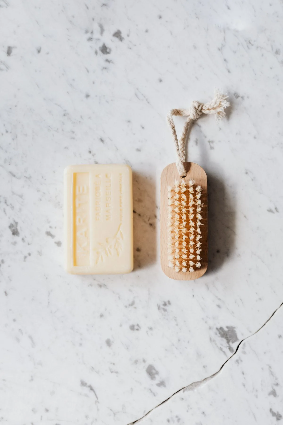 Brosse en fibres et savon, illustrant le matériel simple privilégié pour un nettoyage doux
