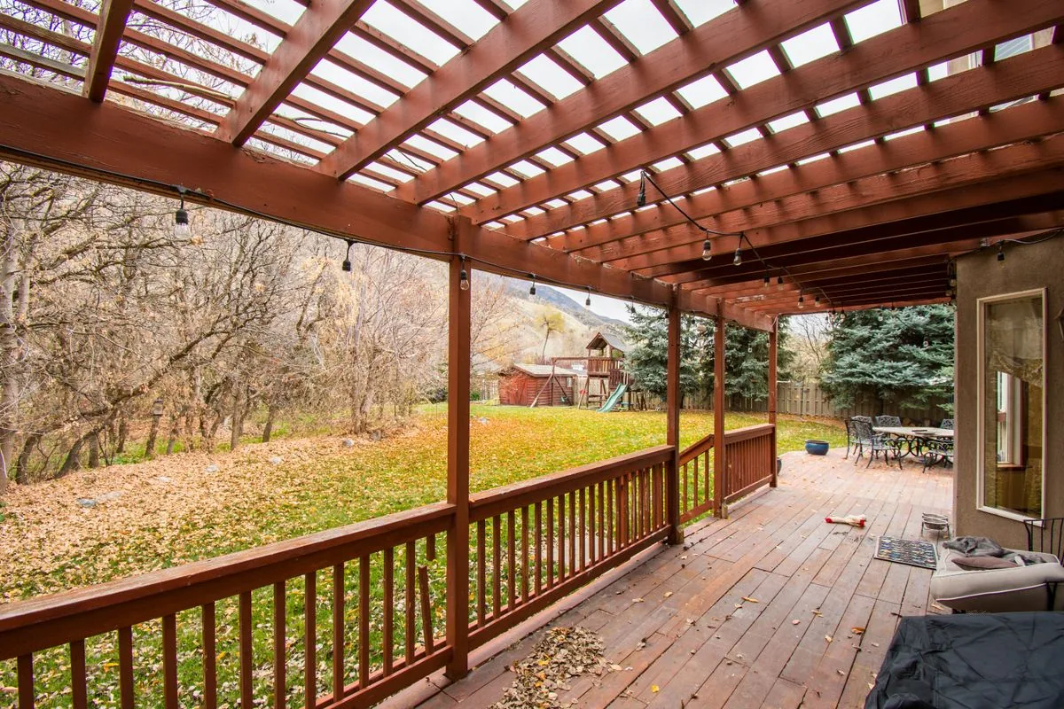 Feuilles d'automne accumulées sur un platelage en bois, exemple concret des gestes d'entretien qui changent selon la saison