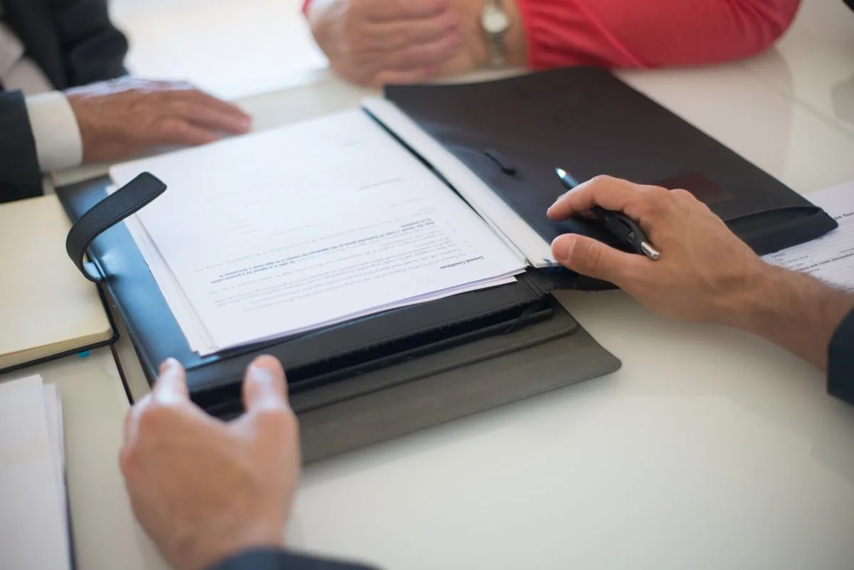 Discussion autour de documents et d'un dossier, illustration de la préparation nécessaire avant une autorisation du syndic ou un vote en assemblée générale