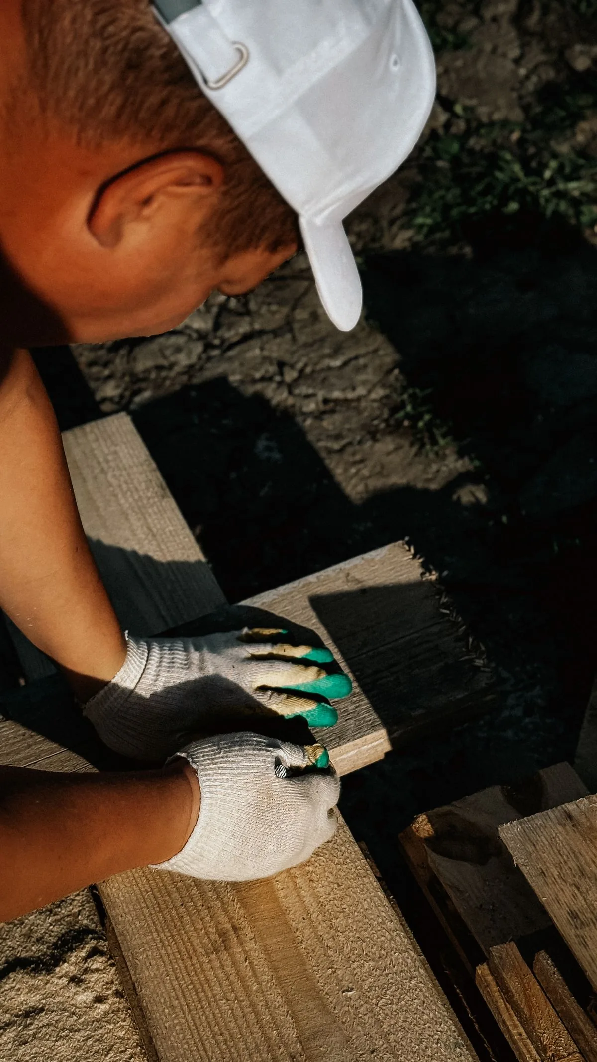 Artisan traçant précisément une pièce de bois, illustrant sections, entraxes et préparation de la structure