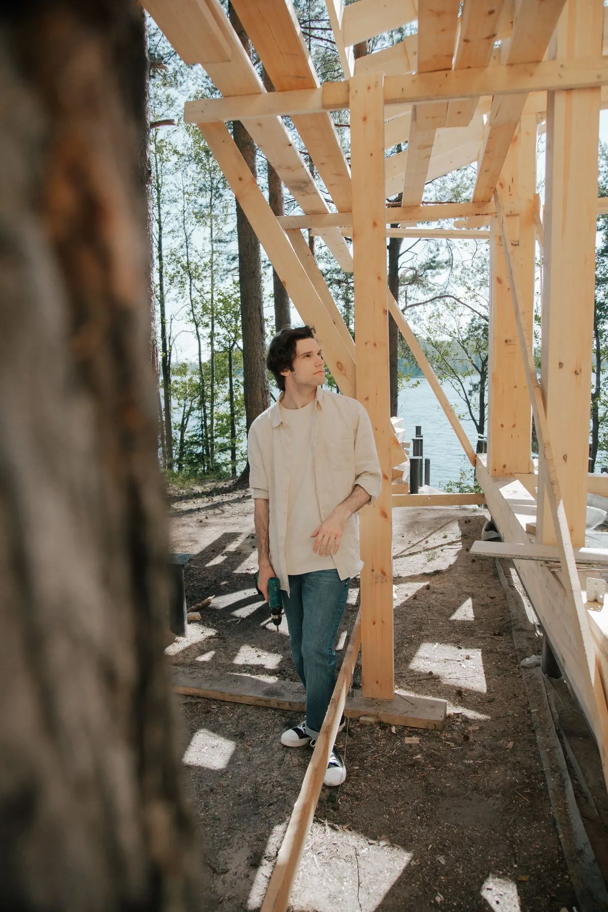 Charpentier travaillant sur une ossature en bois extérieure, illustration du rôle de la structure dans la rigidité et la stabilité d'un platelage