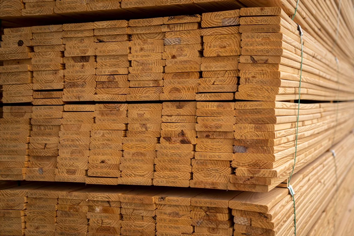 Planches de bois empilées et supportées avant utilisation, illustration de l'importance du stockage des lames avant leur mise en œuvre