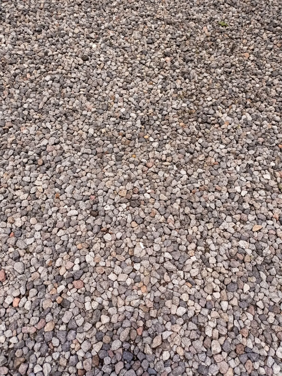 Couche de gravier et fragments minéraux illustrant un matériau pouvant participer à la stabilisation et au drainage d'un sol