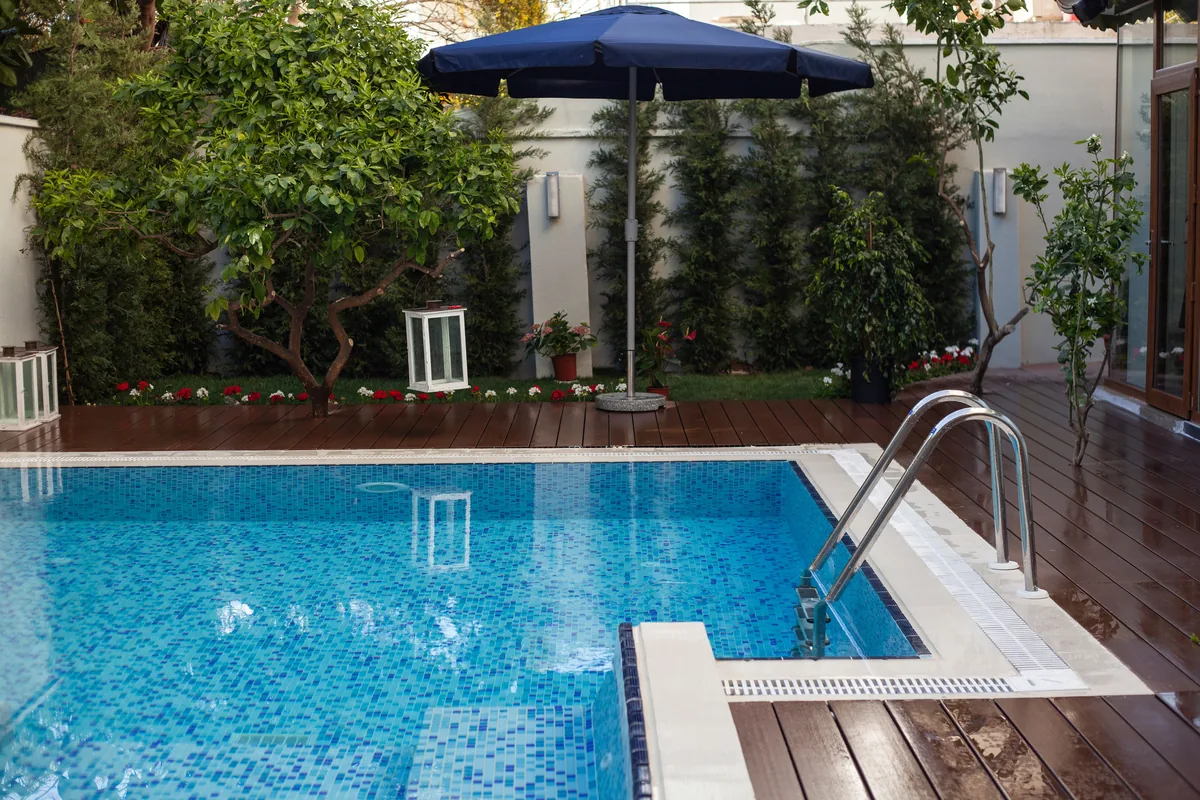 Terrasse en bois autour d'une piscine illustrant les contraintes d'usage, d'humidité et de confort pieds nus