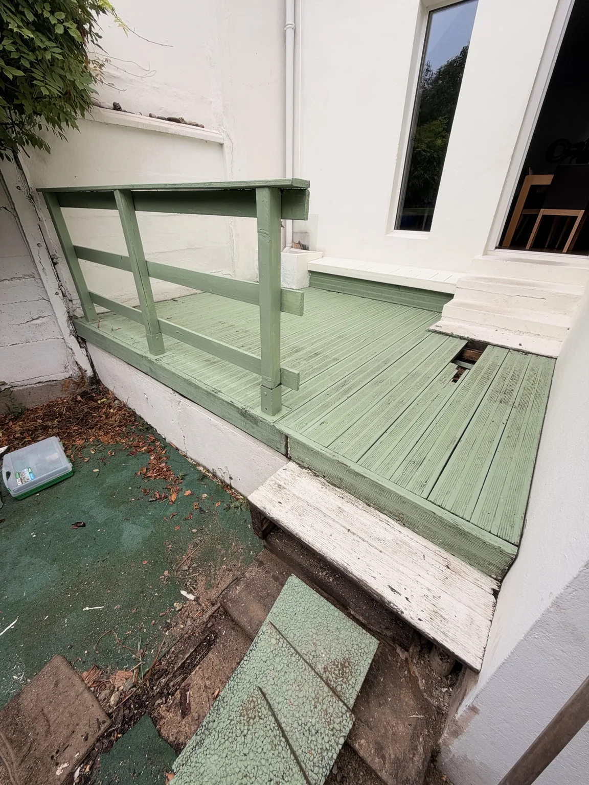 Avant rénovation : ancienne terrasse en bois peinte en vert, lames abîmées et garde-corps dans une cour aux Chartrons