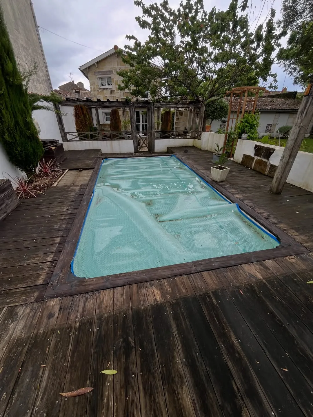 Ancienne terrasse en pin autour d’une piscine à Cestas avant réfection